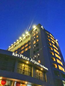 Un grand bâtiment avec un panneau en haut dans l'établissement Kin Plaza Arjaan by Rotana, à Kinshasa