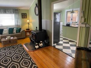 a living room with a couch and a tv in it at Marlay Cottage in Stanthorpe