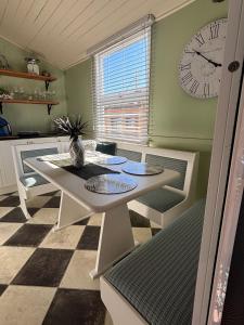 a dining room with a table and a clock on the wall at Marlay Cottage in Stanthorpe