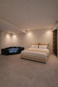 a bedroom with a bed and a tub at Andromeda Suite Private Jacuzzi & Cave Shower in Athens