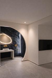 a room with a wall with a tv and a stone wall at Andromeda Suite Private Jacuzzi & Cave Shower in Athens