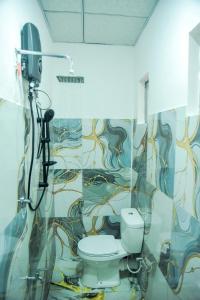 a bathroom with a toilet and a painting on the wall at Misty Peaks Villa in Haldummulla