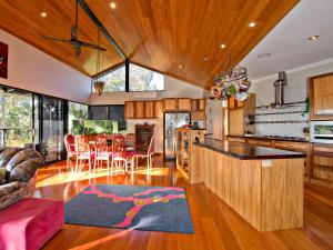 an open kitchen and living room with wooden cabinets at Waters Edge Margaret River Est 2010 in Margaret River Town