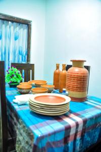 a table with plates and vases on top of it at Misty Peaks Villa in Haldummulla