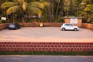 two cars parked in a parking lot with palm trees at Sonika's Paradise (Studio) in Candolim