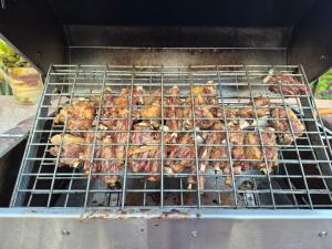 a bunch of chickens cooking on a grill at Orpheus Inn & Glamping in Kaneb Pos