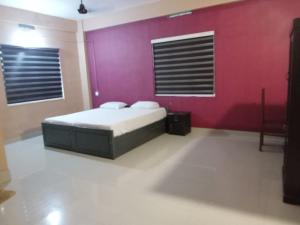 a bedroom with a bed and a red wall at Safa residency hotel in Perintalmanna