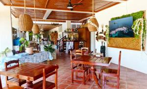 a dining room with wooden tables and chairs at Paruparong Bughaw Ecofarm Resort in Quezon