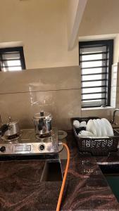 a kitchen with a stove and a basket of dishes at AP'S Homestay Nilambur in Nilambūr