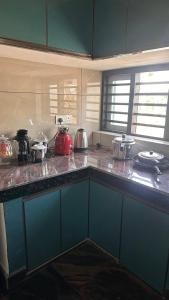 a kitchen with blue cabinets and a counter top at AP'S Homestay Nilambur in Nilambūr