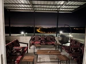 a balcony with couches and a table and chairs at إستراحة حجيف فيو in Salalah
