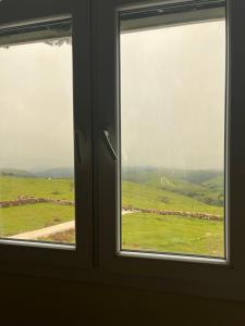 an open window with a view of a field at إستراحة حجيف فيو in Salalah +12 photos