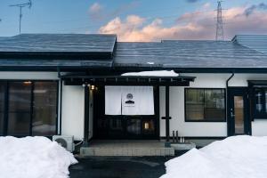 a house with snow on the front of it at Morioka base モリオカベース in Morioka
