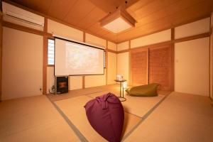 a room with a large projection screen and a purple umbrella at Morioka base モリオカベース in Morioka