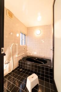 a bathroom with a tub and a toilet in it at Morioka base モリオカベース in Morioka +17 photos