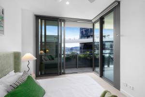 a living room with glass doors and a view of the city at Matcha Madness Zen Escape - Riverfront in Brisbane