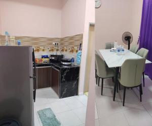a kitchen and dining room with a table and chairs at Jaya's Homestay in Simpang Ampat