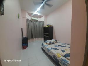 a bedroom with a bed and a ceiling fan at Jaya's Homestay in Simpang Ampat