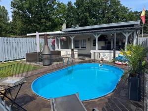 a swimming pool in the backyard of a house at Ferienhaus Lion in Neustadt-Glewe