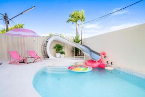 a pool with a slide in the middle of a pool at Candy House Private Pool Villa & KTV in Ban Nong Chaeng