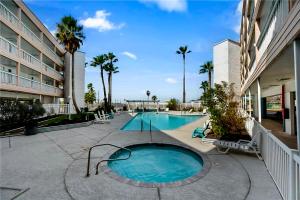 a swimming pool in the middle of a building at The Sandbar Stay - North Beach Waterfront Condo in Corpus Christi