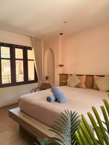 a bedroom with a large bed with a blue towel on it at Barbados Terrace in Ko Samed