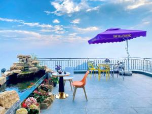 a patio with a table and chairs and an umbrella at Time Villa in Tam Ðảo