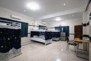 a room with two bunk beds and a table at W H Nest Hostel in Cochin