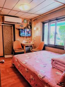 a bedroom with a large bed with chairs and a desk at Yun Cheng Homestay in Jiufen