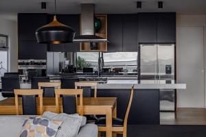 a kitchen with black cabinets and a table and chairs at Elevation in Bicheno