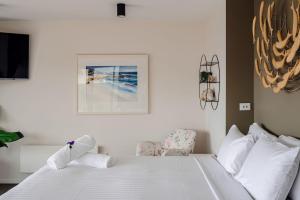 a bedroom with a white bed and a chair at Elevation in Bicheno