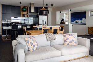 a living room with a white couch and a kitchen at Elevation in Bicheno +35 photos