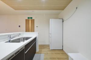 a kitchen with a sink and a refrigerator at Aiki No Yado-Kokuba- in Naha +54 photos
