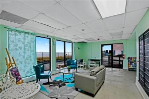 a living room with a couch and chairs and a table at The Sandbar Stay - North Beach Waterfront Condo in Corpus Christi