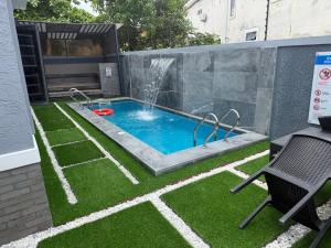 a small swimming pool with a waterfall in a backyard at House 9 Signature in Port Harcourt