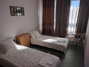 a hotel room with two beds and a table at Berek Szálló in Balatonfenyves +9 photos