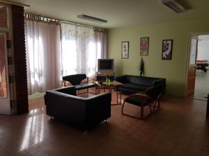 a living room with couches and a table and a television at Berek Szálló in Balatonfenyves