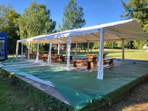 a pavilion with wooden picnic tables under a canopy at Berek Szálló in Balatonfenyves