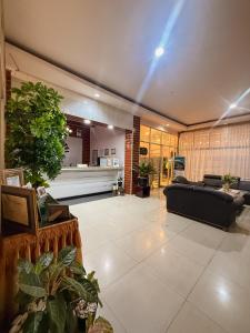 ein Wohnzimmer mit einer Couch und einigen Pflanzen in der Unterkunft arafah hotel in Sungaipenuh