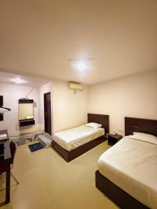 ein Hotelzimmer mit zwei Betten und einem Fernseher in der Unterkunft arafah hotel in Sungaipenuh + 23 Fotos