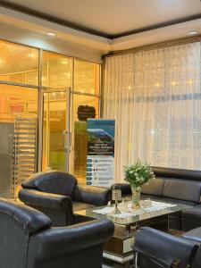 ein Wartezimmer mit Sofas, einem Tisch und Stühlen in der Unterkunft arafah hotel in Sungaipenuh