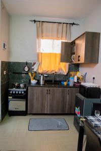 a kitchen with a stove and a window in it at Vine Suites Mbarara - 1 Bed Studio Apartment Near LDC & City Centre - Quiet & Convenient in Mbarara