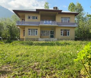 a yellow house on top of a grass field at Bunk Home stay in Srinagar