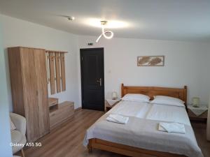 a bedroom with a bed and a black door at Pensiunea Evelyn in Gîrleni