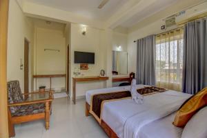 a bedroom with a bed with an animal on it at Atithi Comforts in Kushālnagar