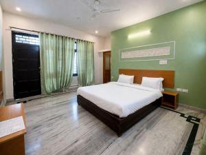a bedroom with a bed and a green wall at Heritage Inn in Lucknow +32 photos