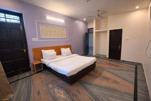 a bedroom with a bed with white sheets and pillows at Heritage Inn in Lucknow