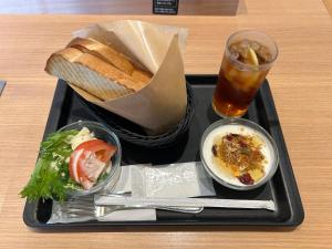 a black tray of food with bread and a drink at Nagano Station Inn East in Nagano +2 photos