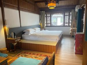 a bedroom with two beds and a window at Baisha Holiday Resort Lijiang in Lijiang