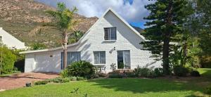 a white house with a palm tree in a yard at White lily in Montagu